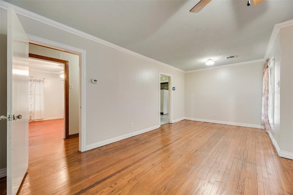 Interior space featuring wood-finish flooring, crown molding, and a ceiling fan