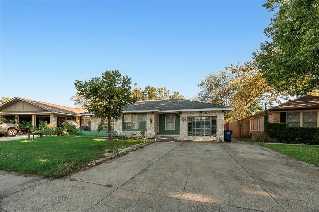 Single-story residence featuring a light-toned masonry exterior, a multi-pane grid window, and a concrete driveway