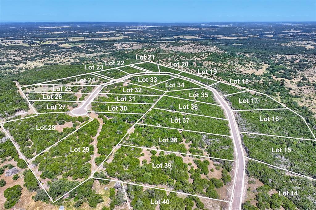 Aerial view of undeveloped land parcels featuring paved road access, varying topography, and native vegetation
