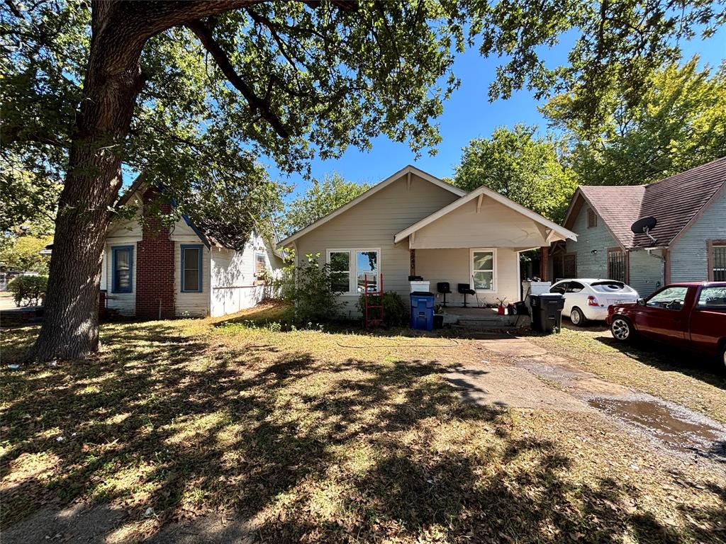 Single-story exterior featuring light-toned horizontal siding, a covered front entry, and mature trees on the lot Single-story exterior featuring light-toned horizontal siding, a covered front entry, and mature trees on the lot