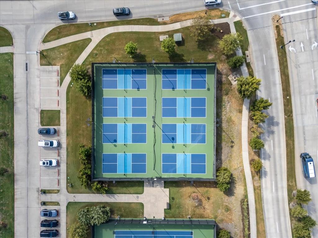 Four enclosed, multi-use outdoor sports courts featuring painted hardcourt surfaces and perimeter fencing