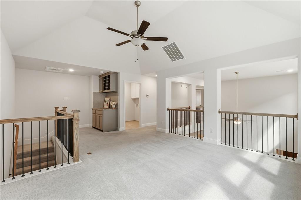 Vaulted ceiling featuring a central ceiling fan and built-in wet bar with cabinetry