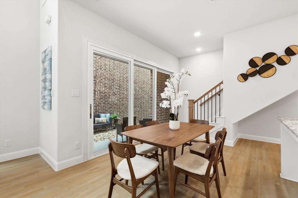Wood-finish flooring, sliding glass door, recessed lighting, and staircase with metal balusters and wood handrail