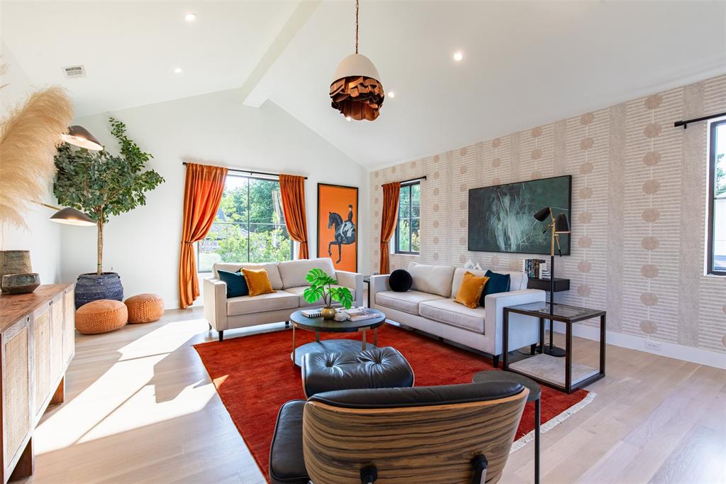 Vaulted ceiling, wood-finish flooring, recessed lighting, and patterned feature wall