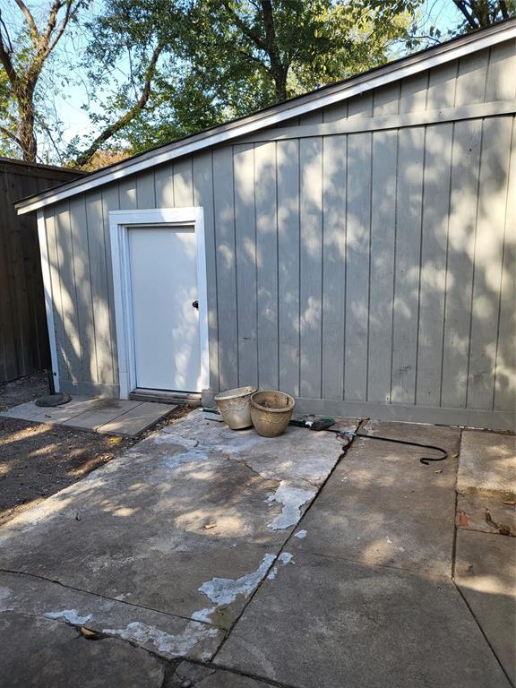 Vertical wood-panel siding and concrete slab patio
