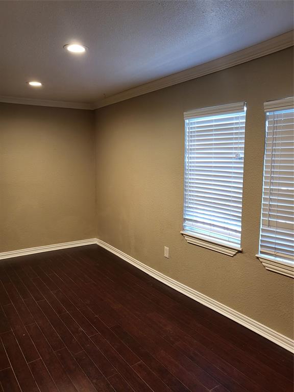 Interior space featuring dark wood-finish flooring, crown molding, recessed lighting, and dual windows with horizontal blinds