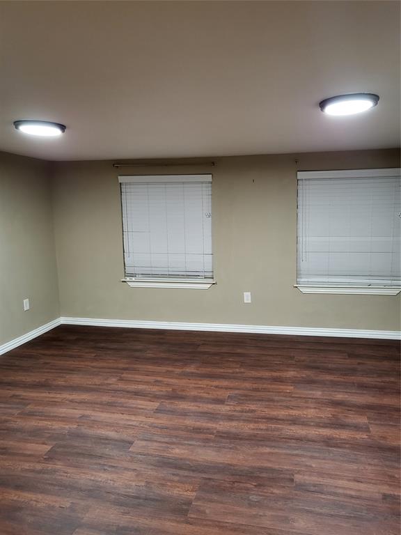 Wood-finish flooring, neutral wall tones, two dual-pane windows, and recessed ceiling lighting