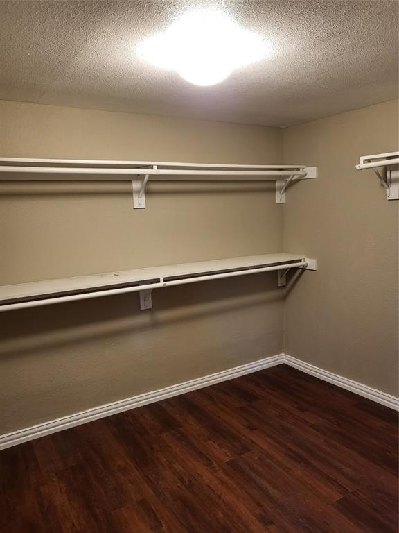 Storage space featuring dual-level metal shelving and wood-finish flooring