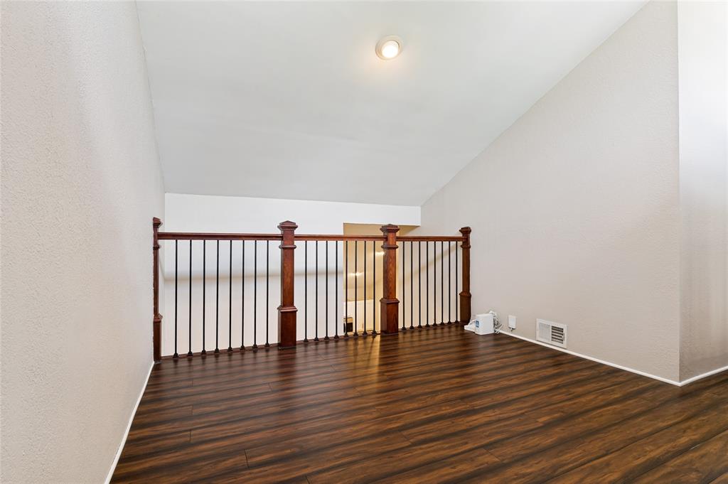 Wood-finish flooring, vaulted ceiling, recessed lighting, and wood and iron railing
