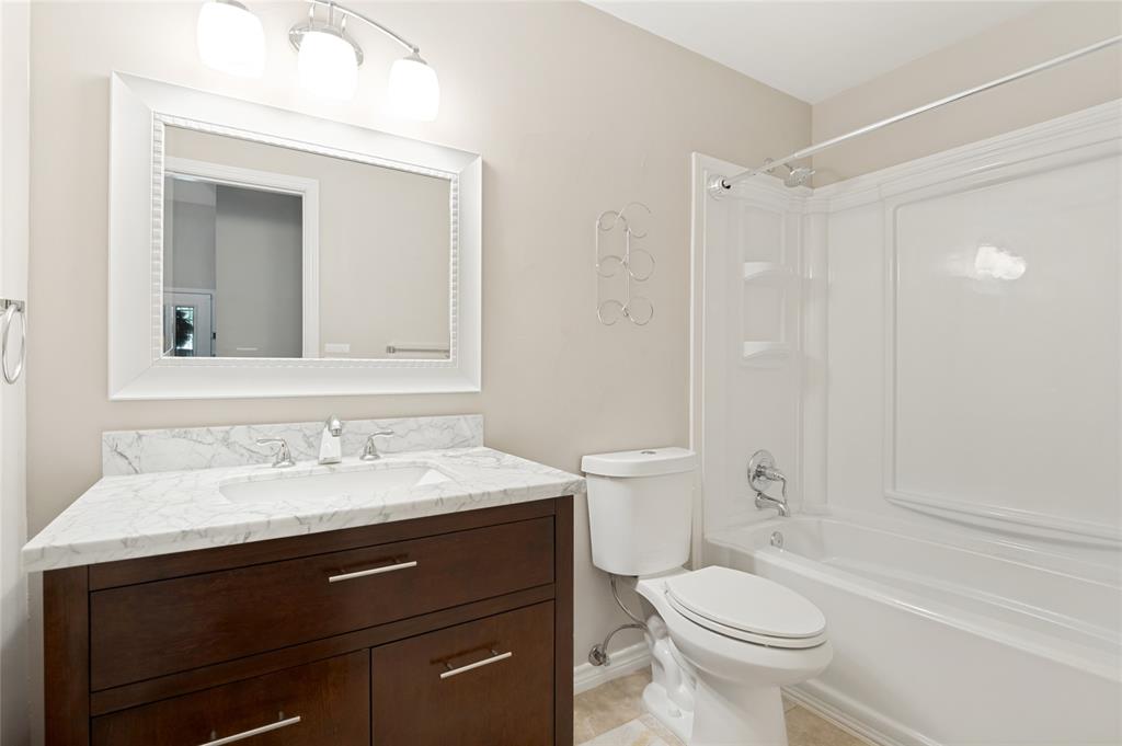 Dark wood-finish vanity with chrome hardware, an integrated sink, and a white stone-finish countertop