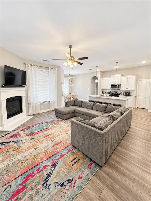 Spacious living room with a gas-log fireplace and big windows that fill the space with natural light.