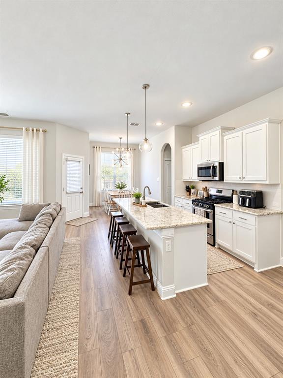 Wood-look flooring flows through the open kitchen and dining area for a seamless, modern feel.