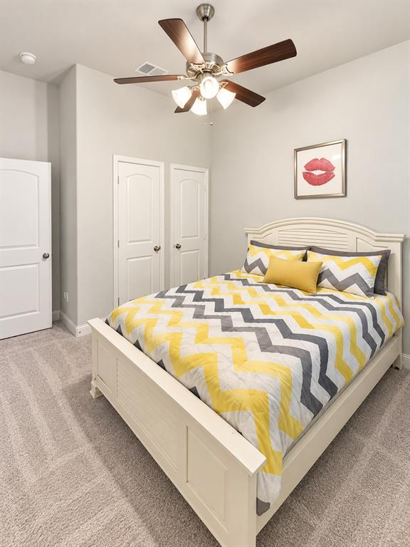Bedroom with a ceiling fan and room for a queen-size bed.