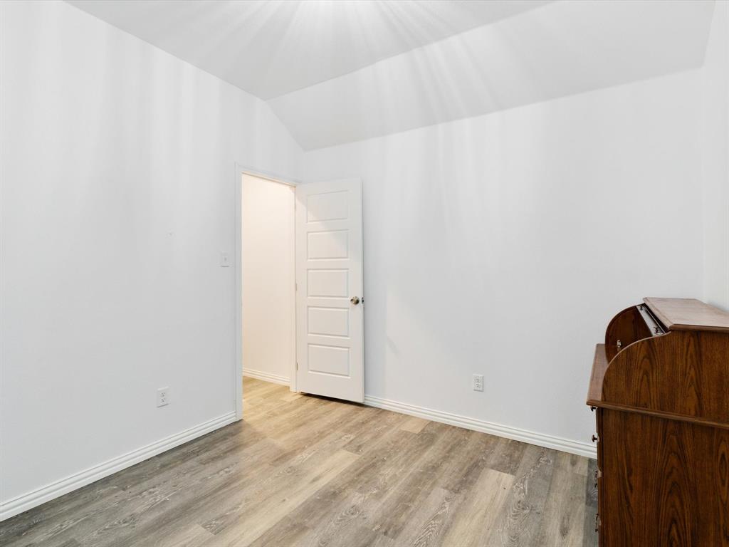 Wood-finish flooring, vaulted ceilings, and a five-panel interior door