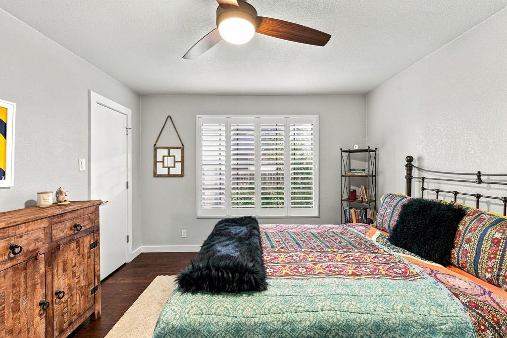 Wood-finish flooring, plantation shutters, and three-blade ceiling fan with integrated lighting