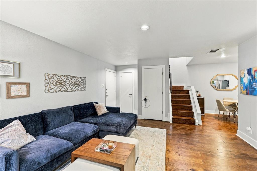 Open floor plan featuring wood-finish flooring, recessed lighting, and a staircase with wood treads and a white balustrade