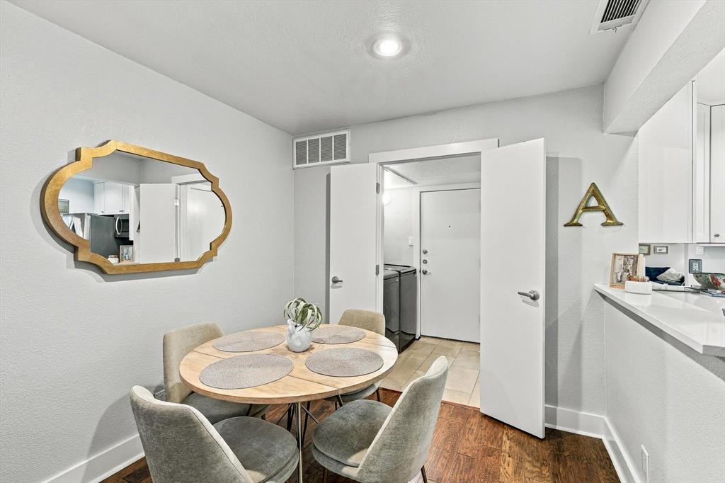 Dining area featuring wood-finish flooring, recessed lighting, and a kitchen pass-through counter with a stone-surface finish