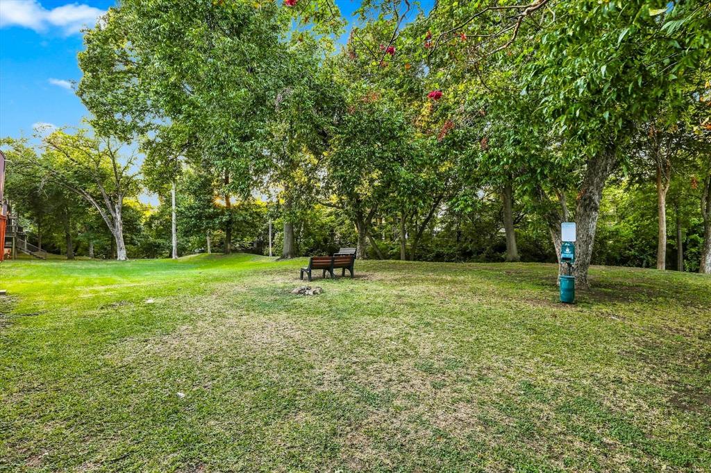 Expansive backyard featuring mature trees, manicured lawn, and natural scenery