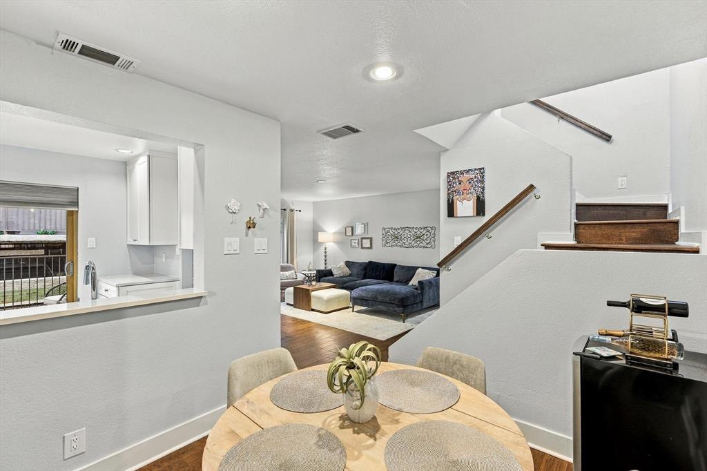 Open floor plan featuring wood-finish flooring, recessed lighting, and a staircase with a wood handrail