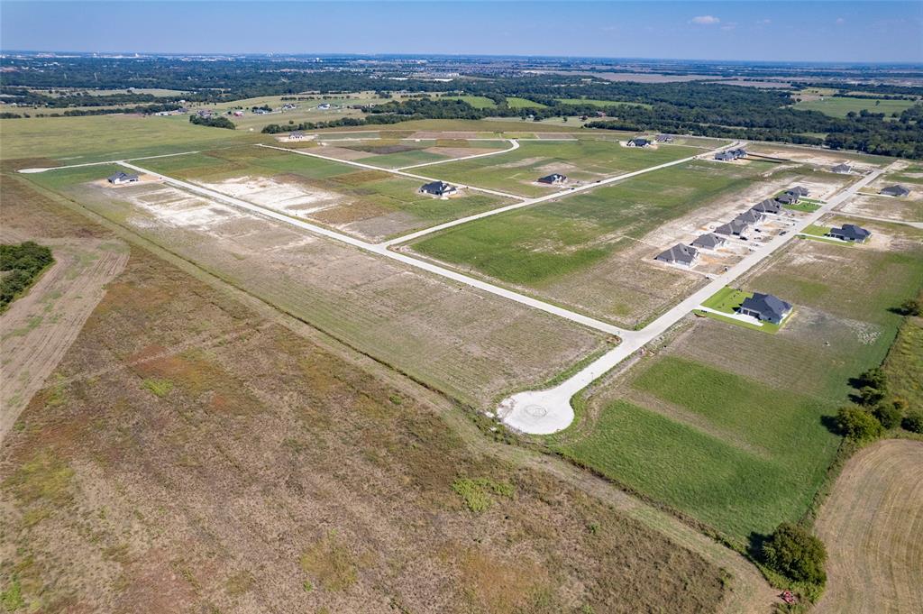 Aerial perspective of a master-planned community featuring concrete cul-de-sacs, paved roads, and expansive undeveloped lots