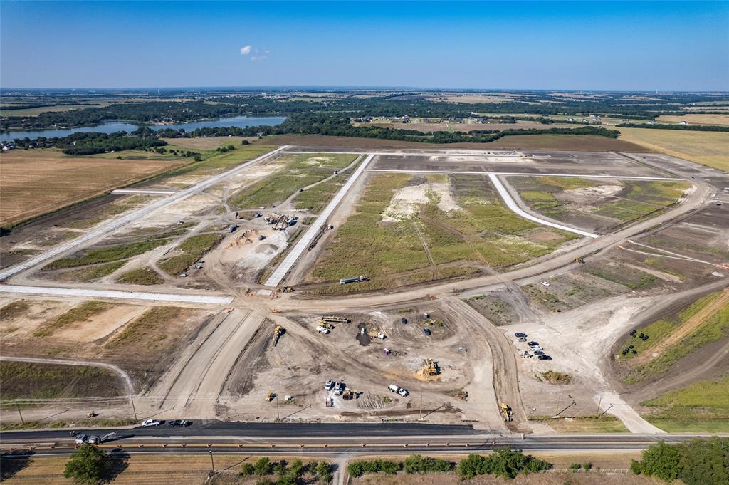 Large-scale residential development site featuring prepared land parcels, established paved road infrastructure, and water frontage