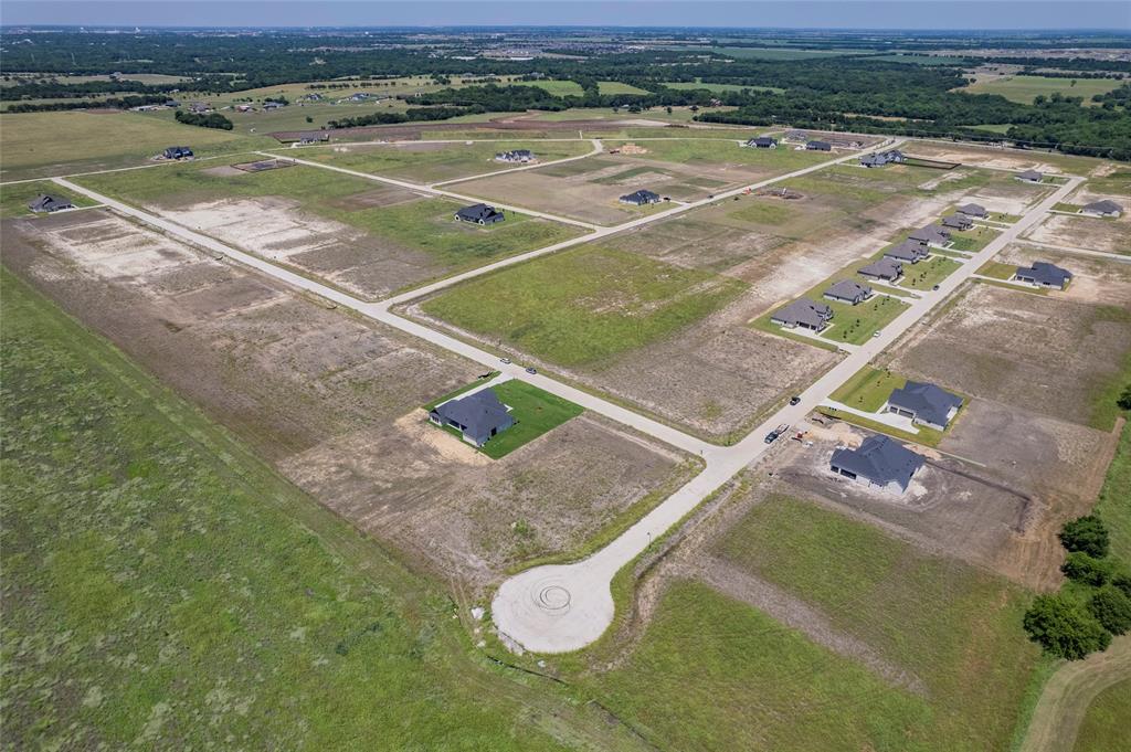 Aerial perspective of a development featuring paved cul-de-sac streets, cleared residential lots, and established asphalt roadways