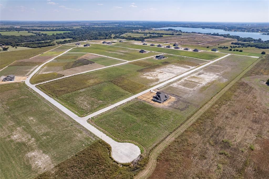Aerial perspective of undeveloped land plots featuring paved roads, cul-de-sacs, and proximity to open water