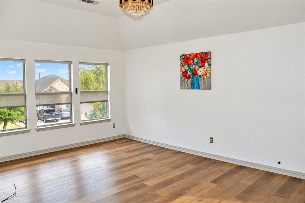 Vaulted ceiling with a multi-tiered crystal chandelier, wood-finish flooring, and expansive windows