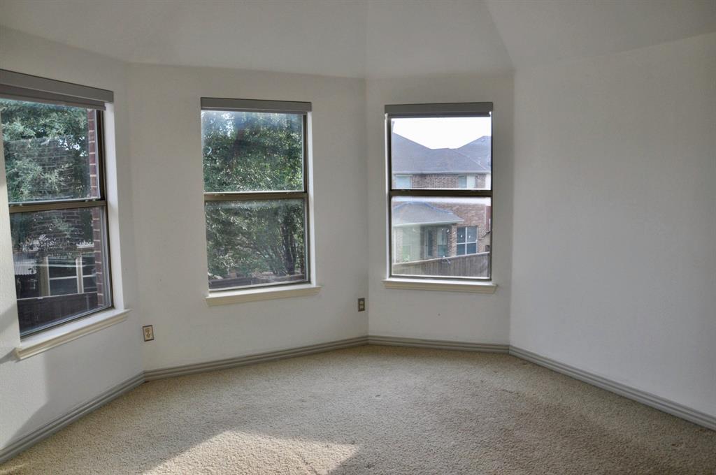 Bay window featuring three single-hung windows, vaulted ceiling, and neutral wall-to-wall carpeting