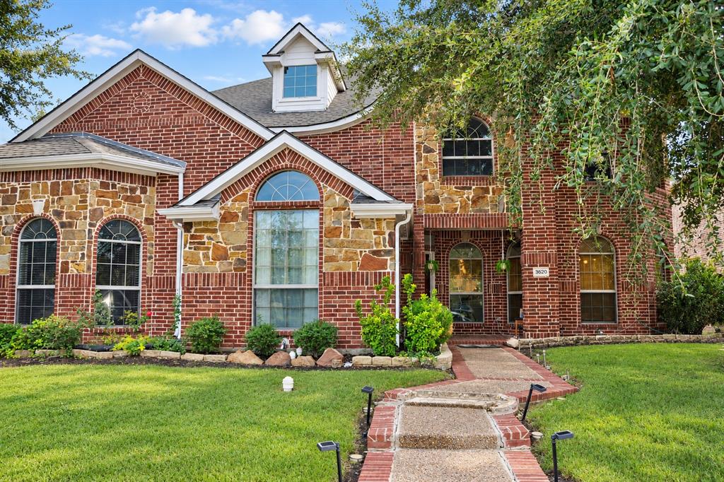 Red brick exterior featuring stone accents, arched windows, a front-facing gable, and a paved walkway Red brick exterior featuring stone accents, arched windows, a front-facing gable, and a paved walkway