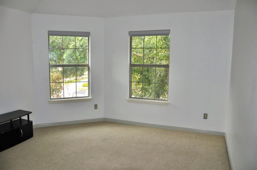 Neutral-toned wall-to-wall carpeting and dual grid-pattern windows featuring built-in roller shades