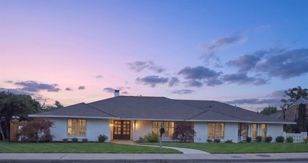 Single-story brick exterior featuring a low-pitched roof, multi-pane double front doors, large divided-light windows, and a paved walkway