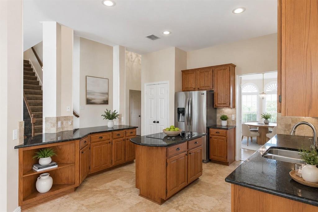 Chef-inspired kitchen with granite counters, center island, stainless appliances and tons of cabinet storage.