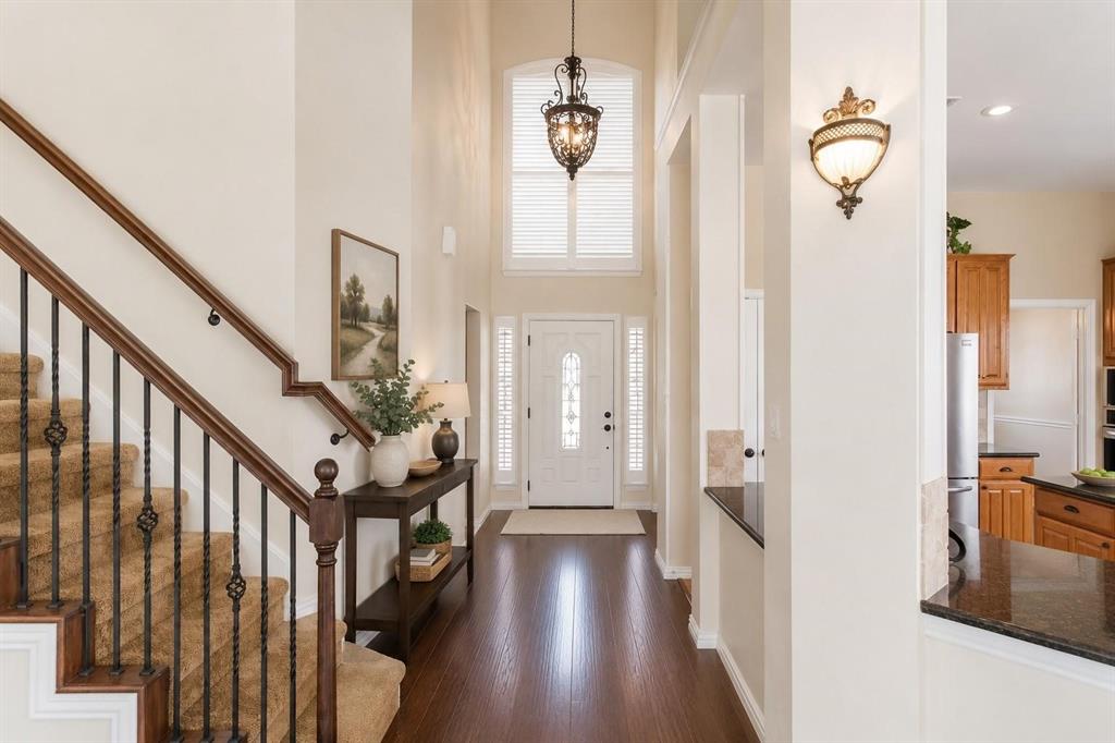 Grand two-story entry with sweeping staircase, gleaming wood floors and abundant natural light.