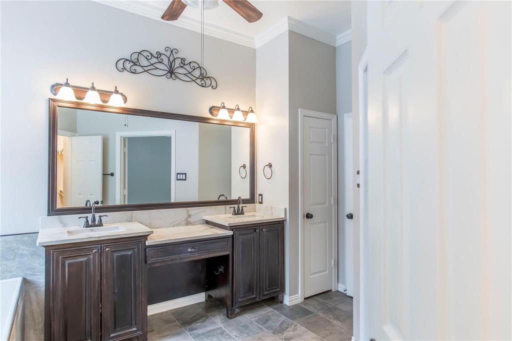 Spacious bath with double sinks, large mirror and modern lighting.