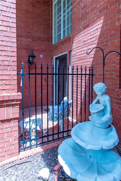 Charming courtyard entry with decorative wrought-iron gate and fountain accent - a warm welcome home.