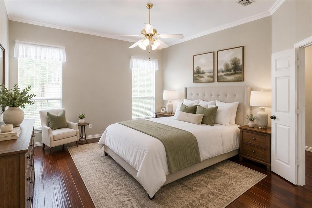 Serene bedroom retreat with wood floors, ceiling fan and plenty of natural light.