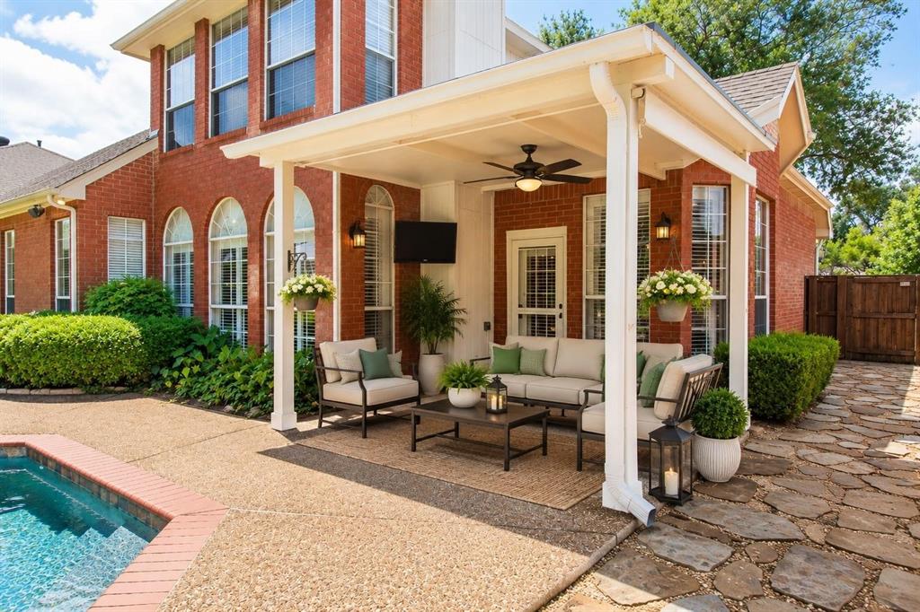 Outdoor living at its best: covered patio with ceiling fan and sparkling pool views. Virtually staged.