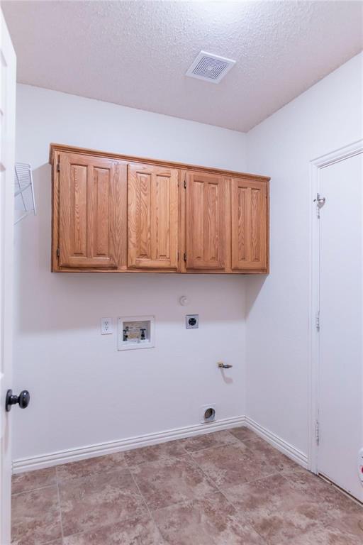 Dedicated laundry room with built-in cabinets for extra storage.