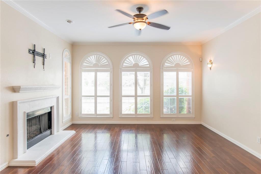 Inviting living room with fireplace, ceiling fan and arched windows - move-in ready!