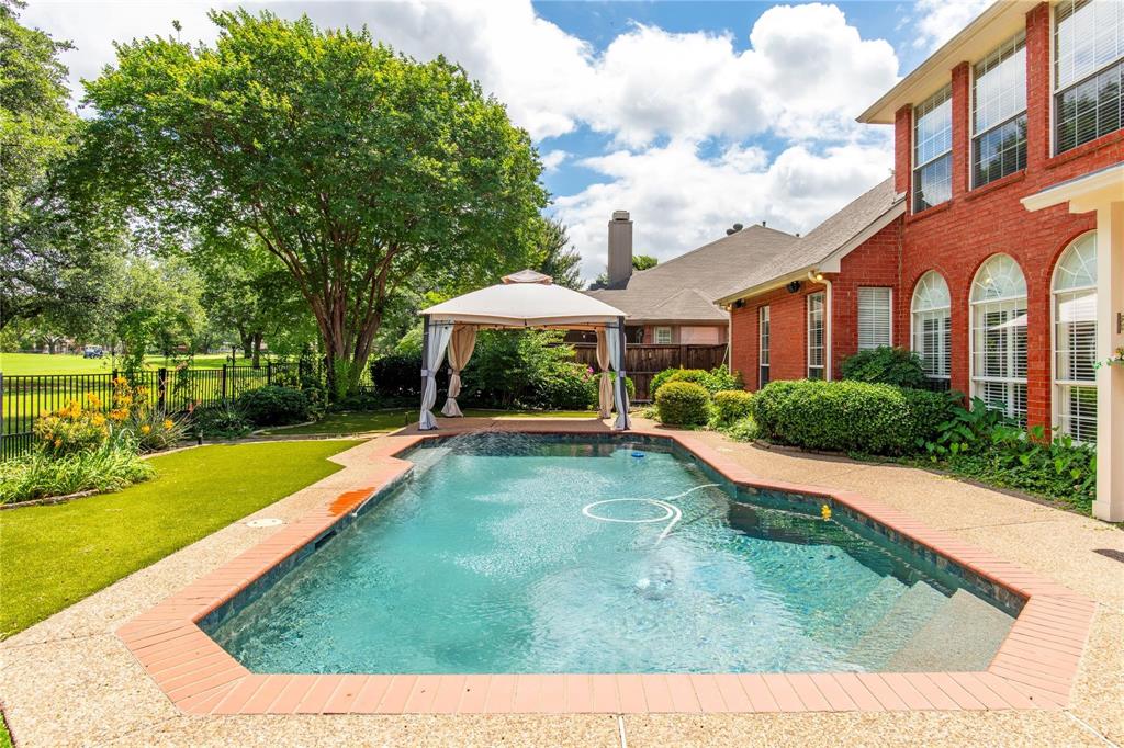 Sparkling pool surrounded by lush green lawn and mature trees - summer fun right at home.