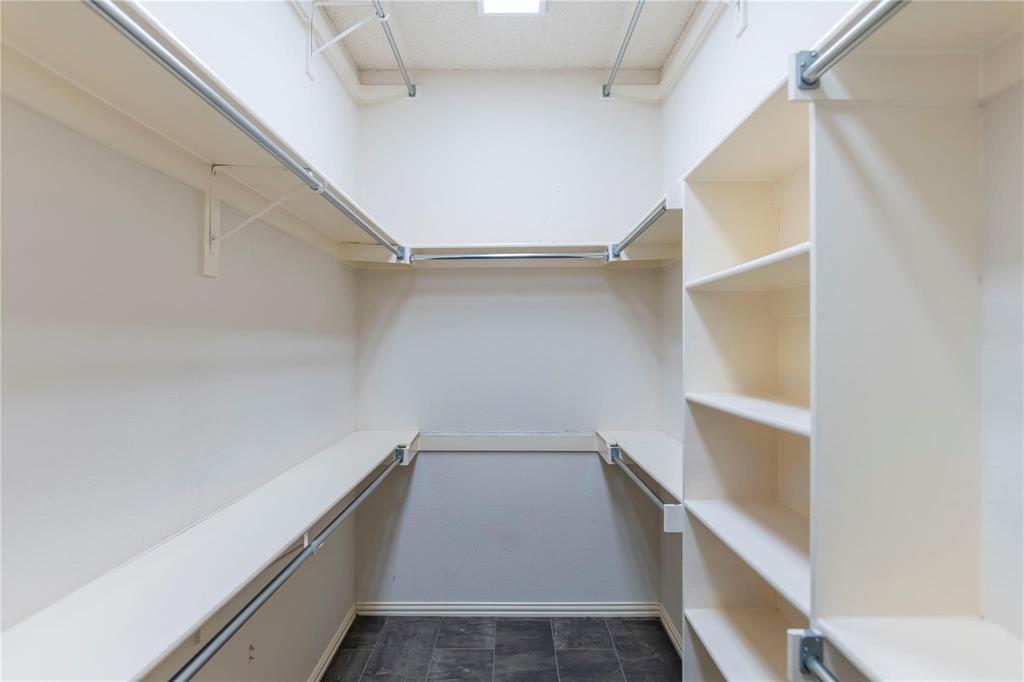 Generous walk-in closet with built-in shelving - storage for days!