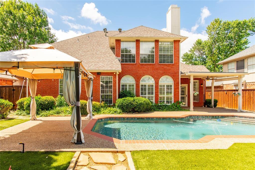 Entertain in style: covered pergola patio overlooks the pool and lush landscaping - made for summer evenings.