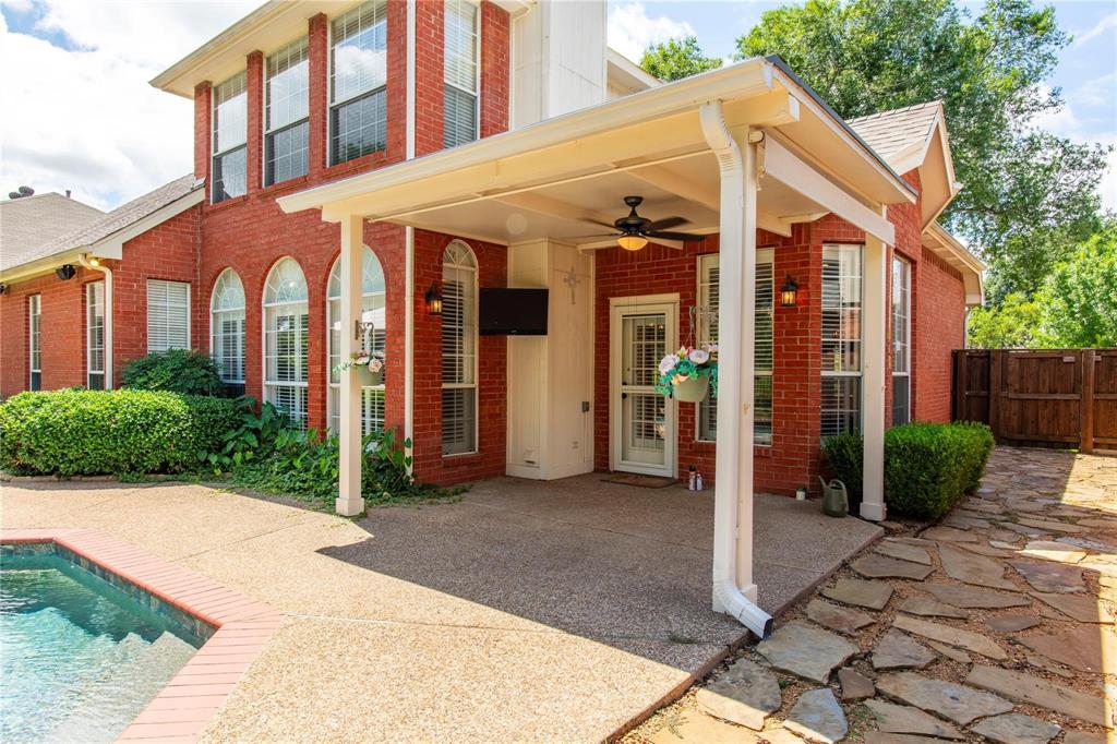 Classic brick two-story with covered patio and pool - private backyard living at its finest.