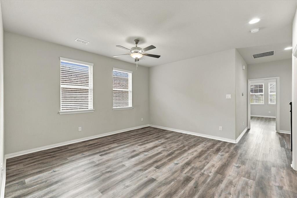 Neutral-toned interior featuring wood-finish flooring, a ceiling fan with integrated lighting, recessed lighting, and double-paned windows