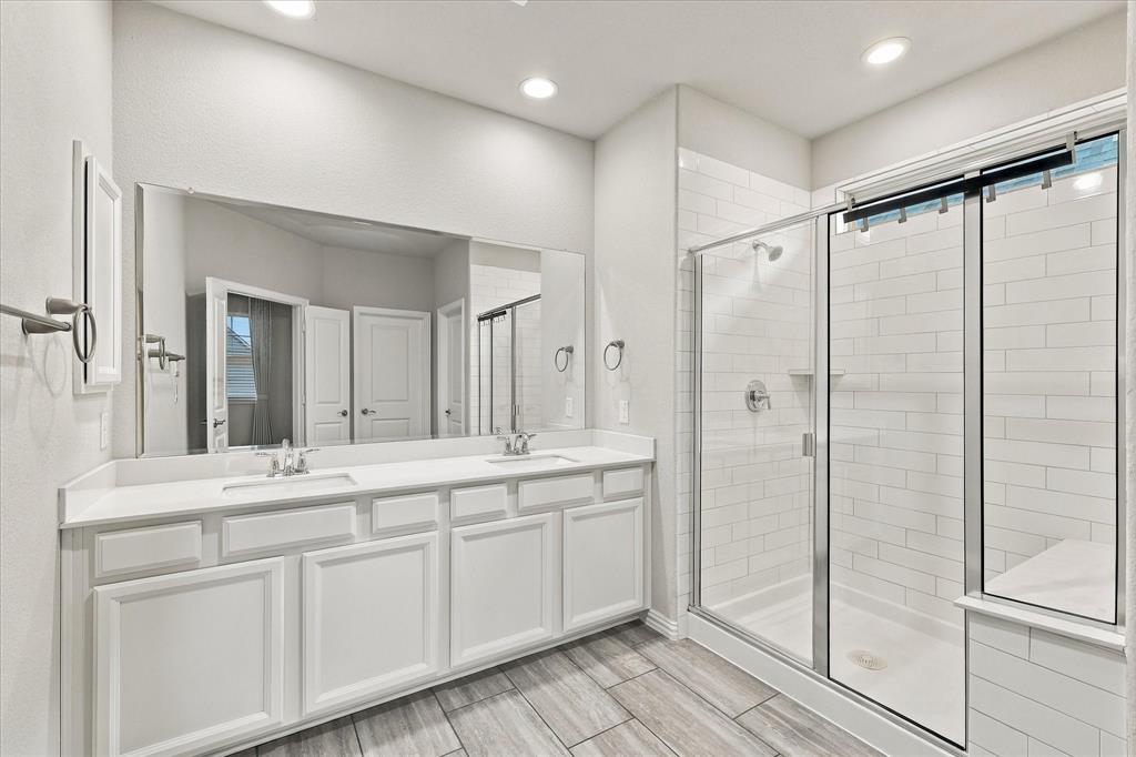 Double vanity with white cabinetry, rectangular under-mount sinks, and large wall-to-wall mirror