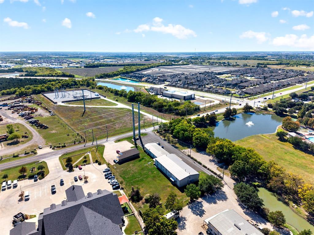 Aerial perspective featuring multiple industrial-style structures, paved parking areas, and surrounding bodies of water