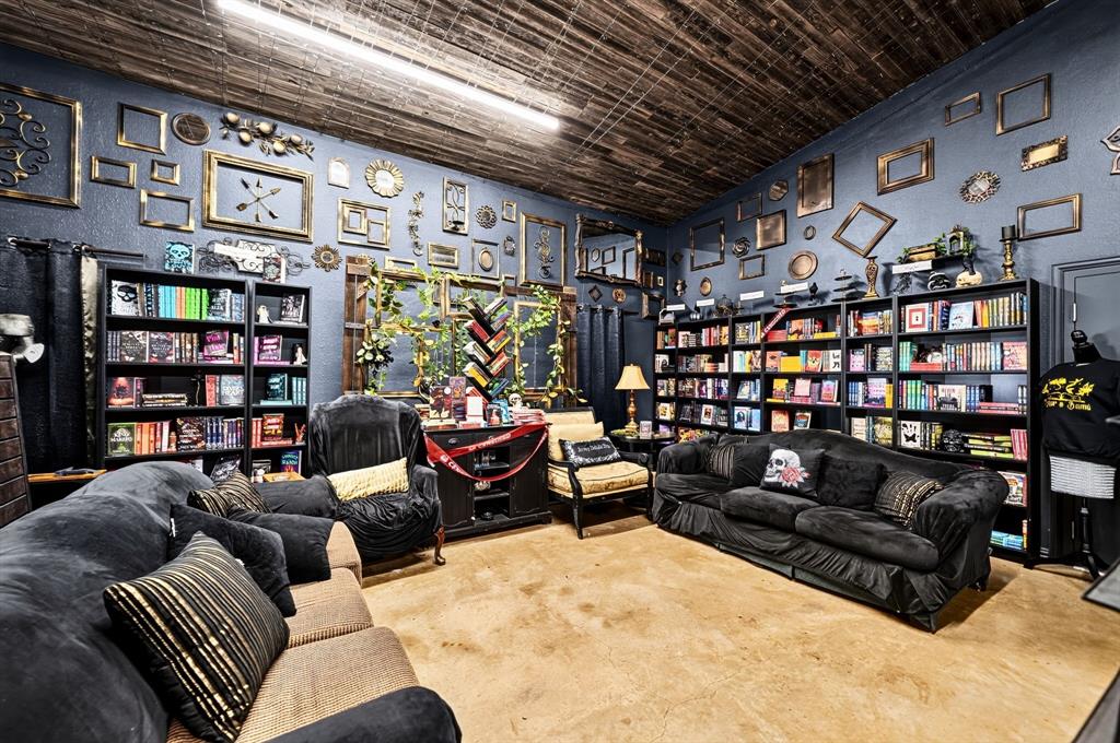 Room featuring wood-plank ceiling, stained concrete flooring, and built-in floor-to-ceiling shelving