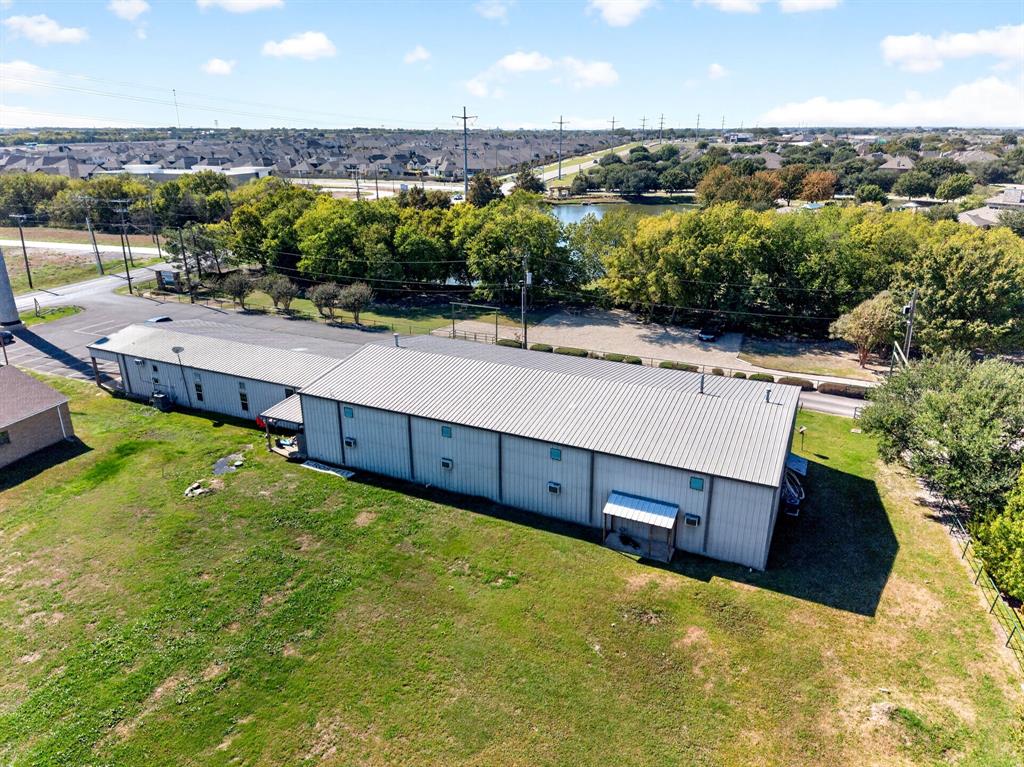Expansive metal-sided structure featuring a standing seam metal roof and a spacious lawn surrounding the building exterior