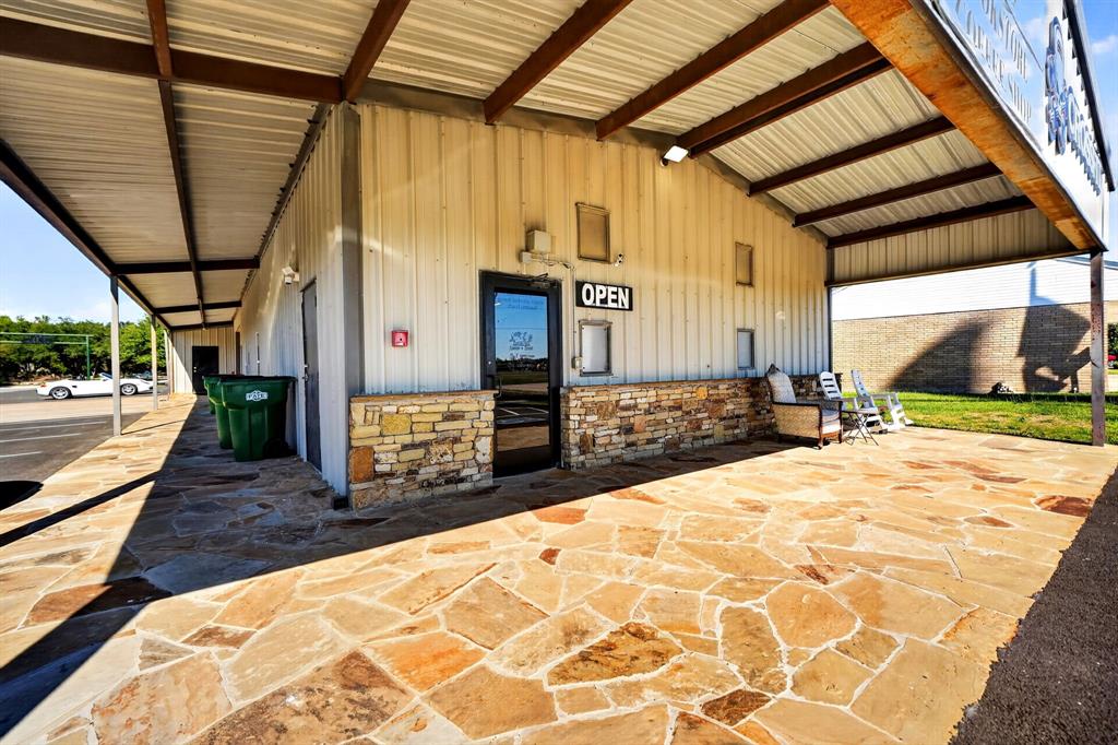 Metal-clad exterior featuring a flagstone patio, covered porch, and stone facade accents